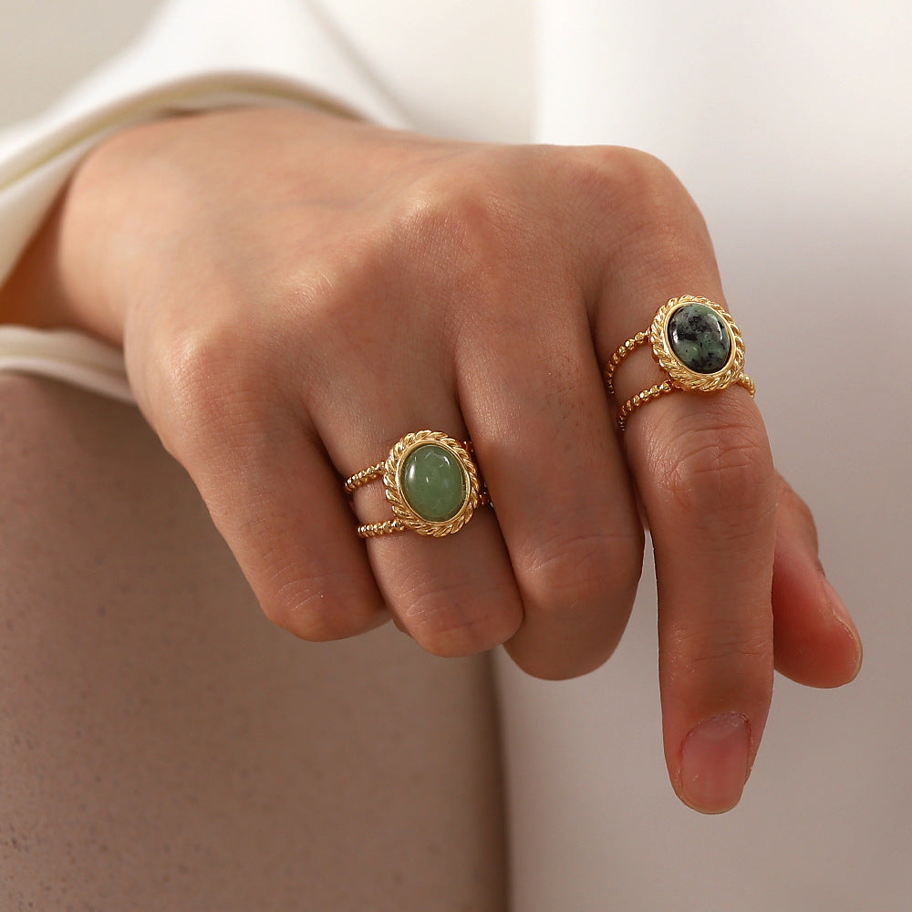 woman's hand posing for 2 green rings on 