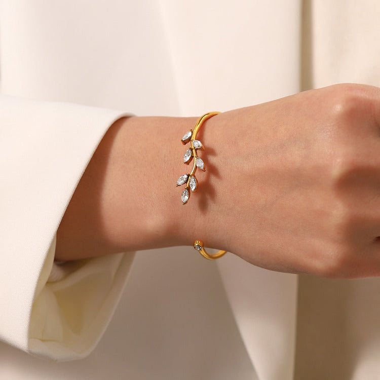 lady in a khaki suit showing her wrist with a bracelet on 