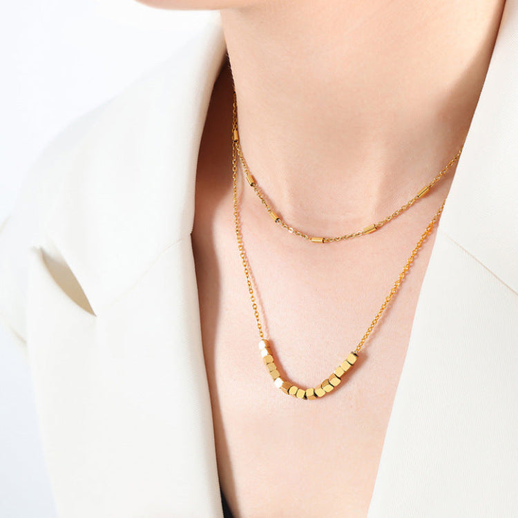 woman neck/chest area showing with a double layered necklace on 