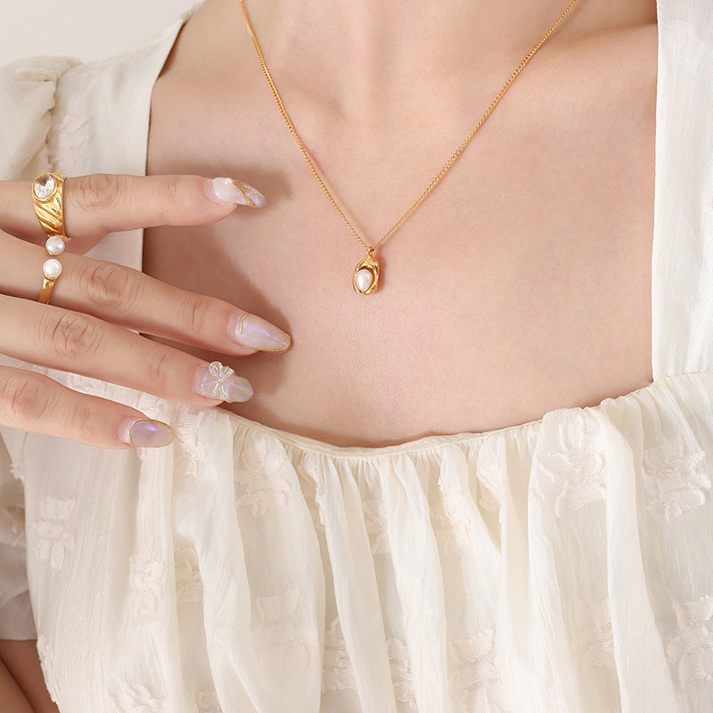woman chest area with pearl necklace on posing for the pearl necklace with white shirt on and long nails