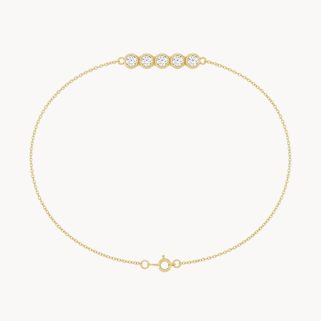 Gold bracelet with three clear gemstones on a white background