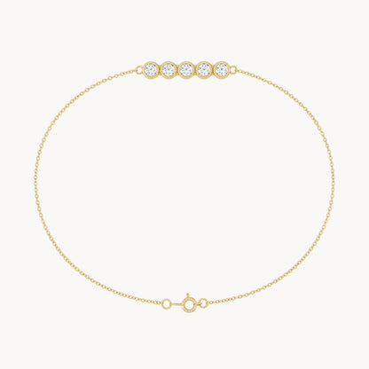 Gold bracelet with three clear gemstones on a white background