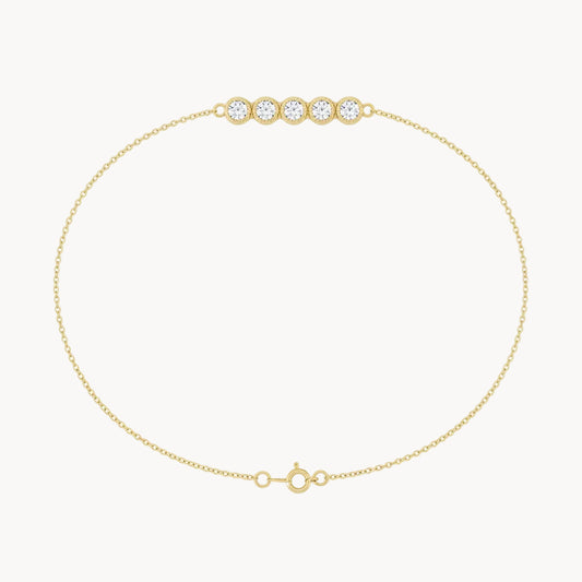 Gold bracelet with three clear gemstones on a white background