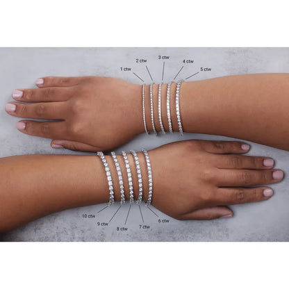 Two arms with diamond bracelets on a gray background, showing weight measurements.