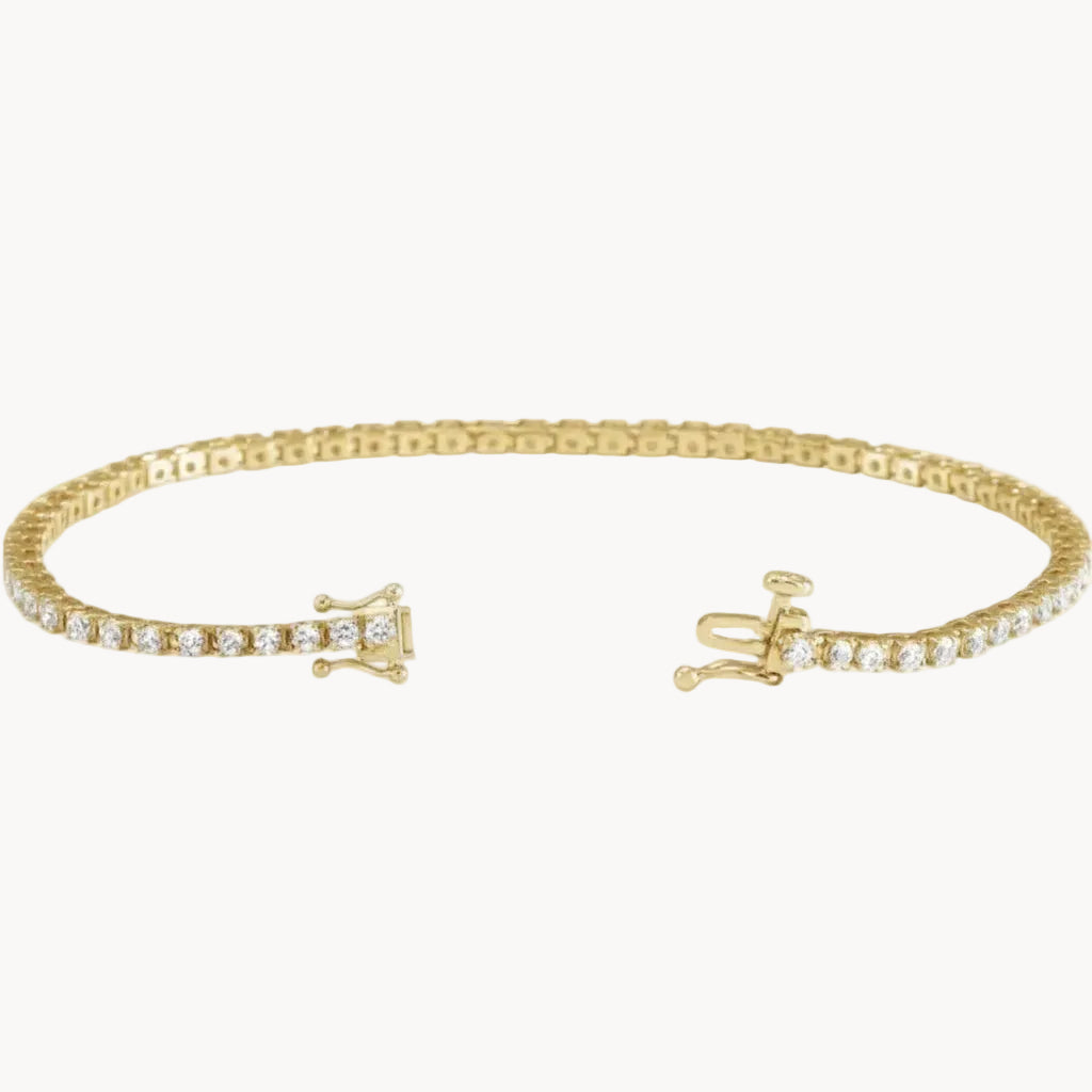 Gold bracelet with diamond accents on a white background