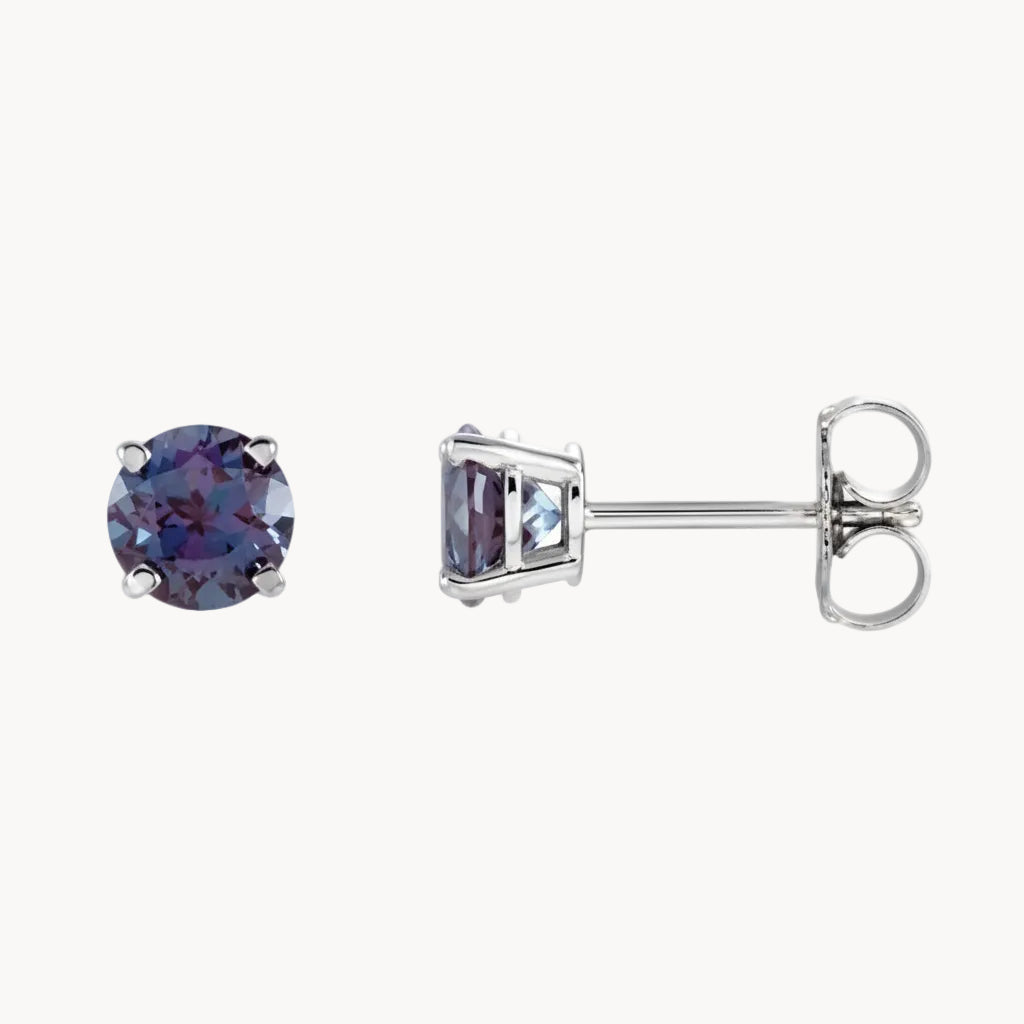 Pair of stud earrings with purple gemstones on a white background