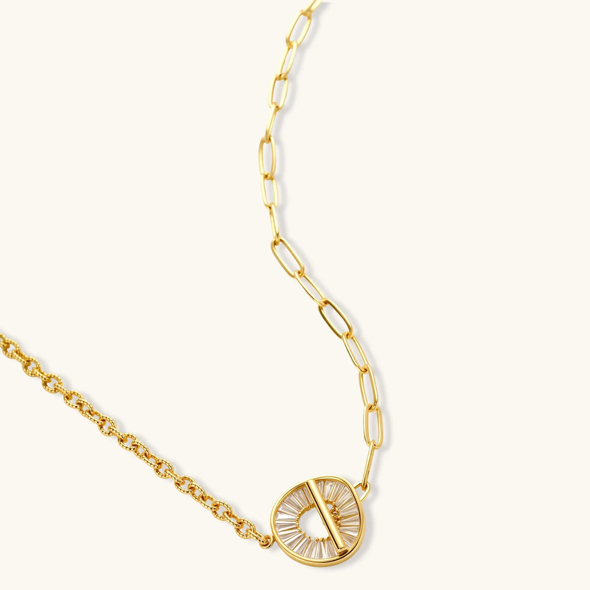 Gold chain necklace with a circular pendant on a white background