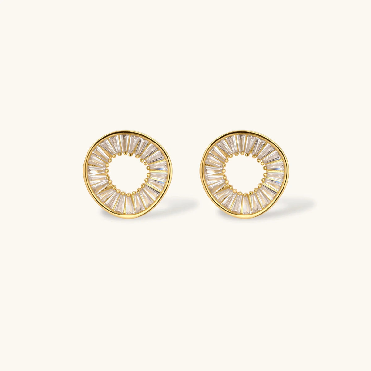 Gold hoop earrings with clear gemstones on a white background