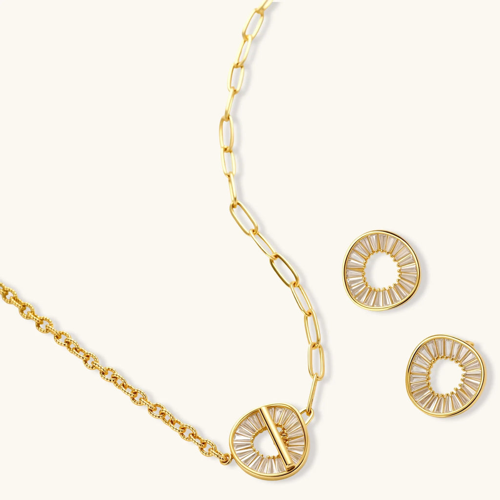 Gold necklace and earrings set on a white background