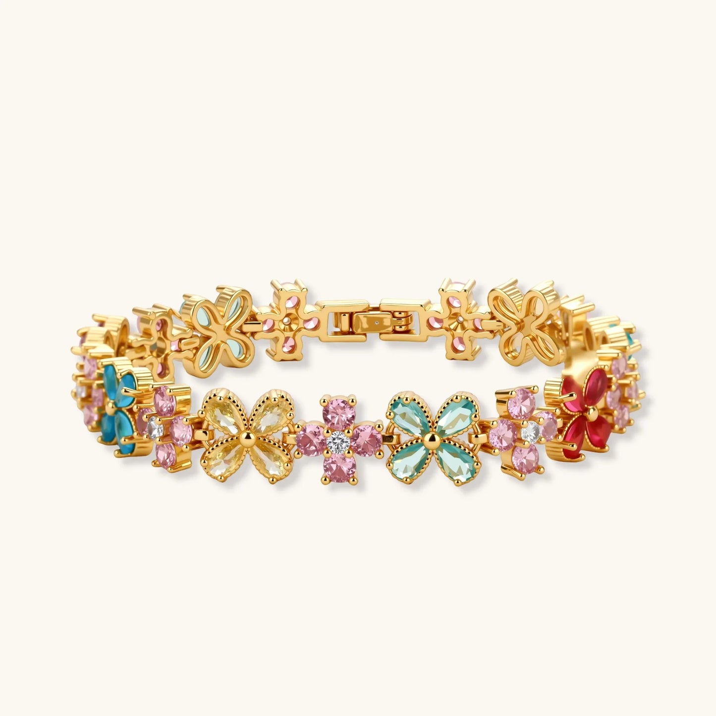 Gold-plated jewelry set with pink, turquoise and red flower-shaped cubic zirconia stones, featuring necklace, earrings and bracelet.