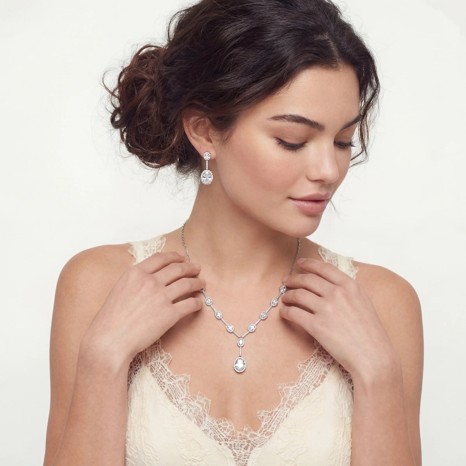 Woman wearing a diamond necklace and earrings on a white background