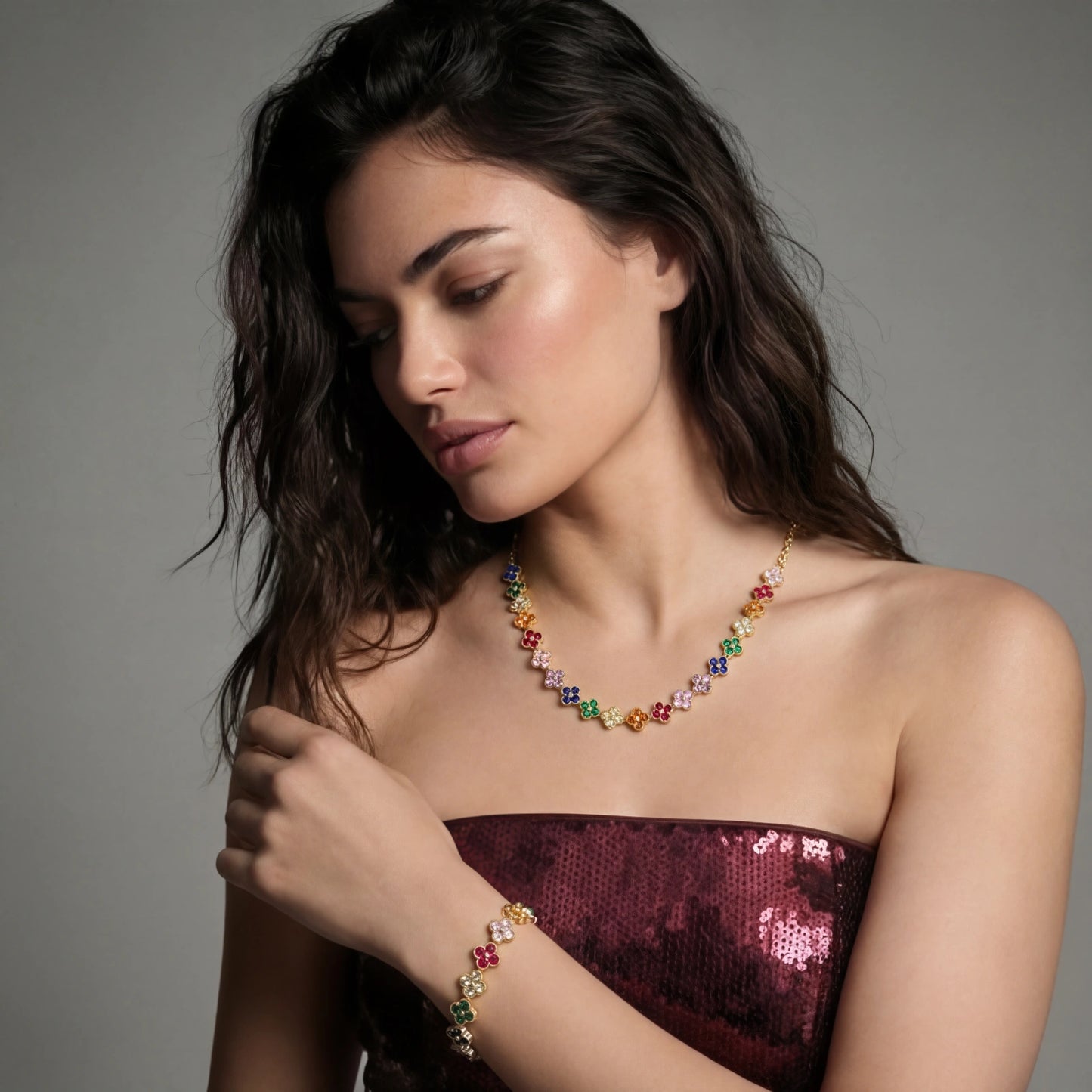 Woman wearing a colorful necklace and bracelet against a gray background