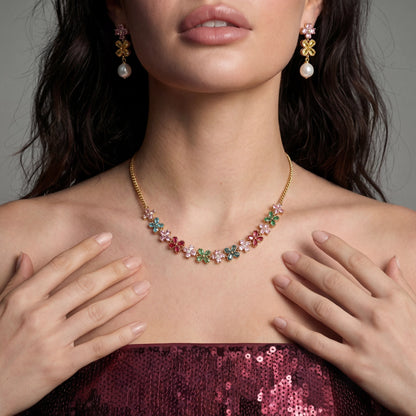 Close-up of a woman wearing a colorful floral necklace and earrings against a neutral background