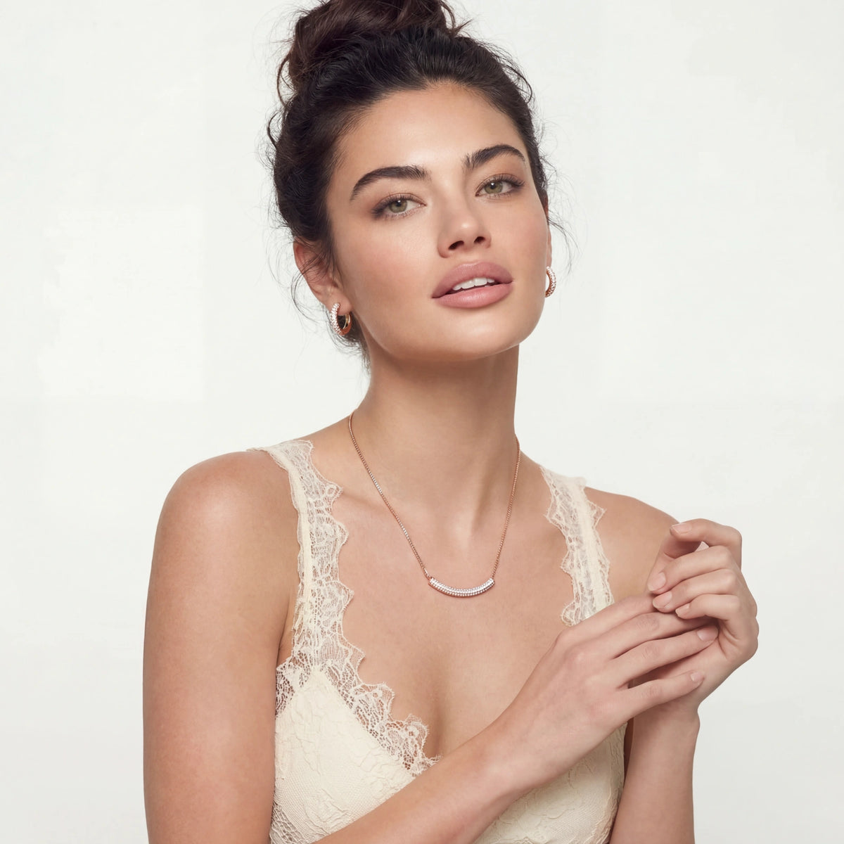 Woman wearing a lace top against a plain background