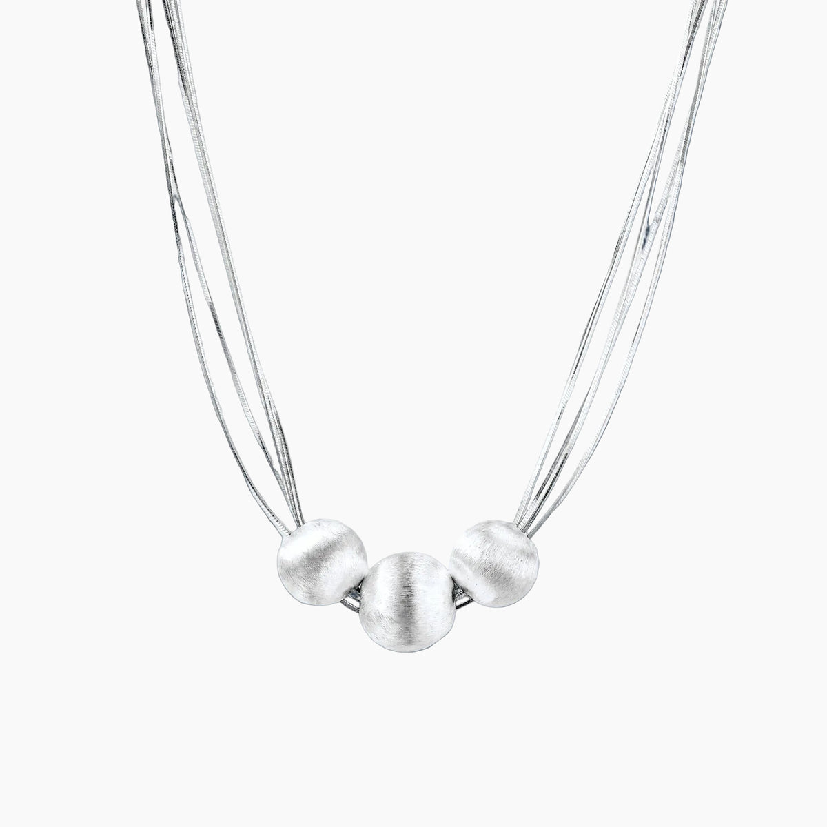 Sterling silver multi-strand necklace with three brushed round beads on cream background