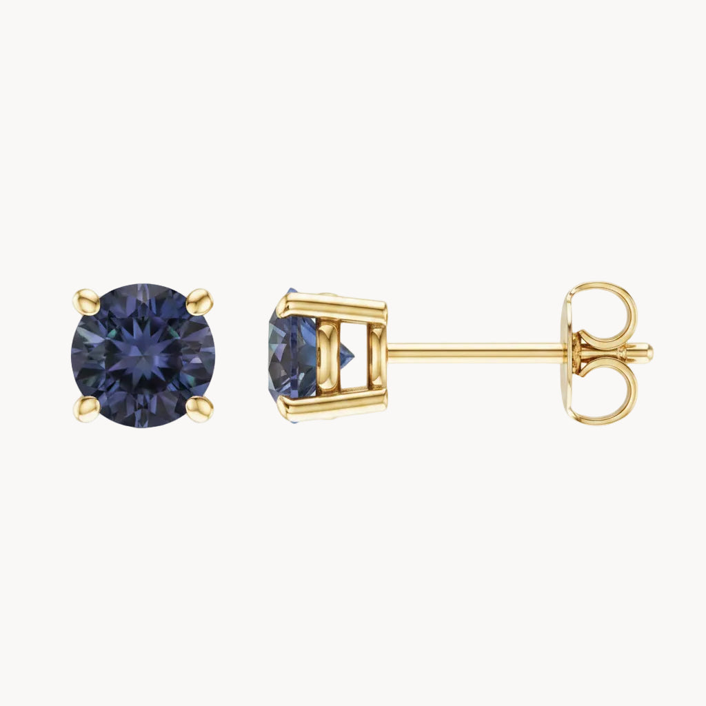 Gold stud earrings with round gemstones on a white background