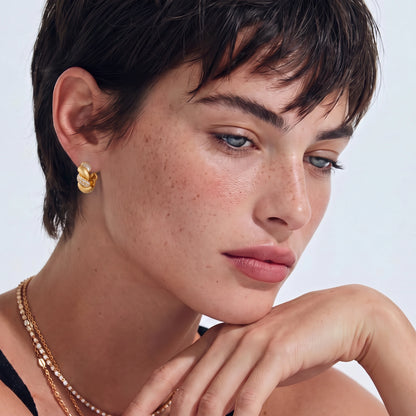Pair of 18K gold-plated 925 silver huggie hoops with twisted braid texture and pavé cubic zirconia detailing, 15mm.