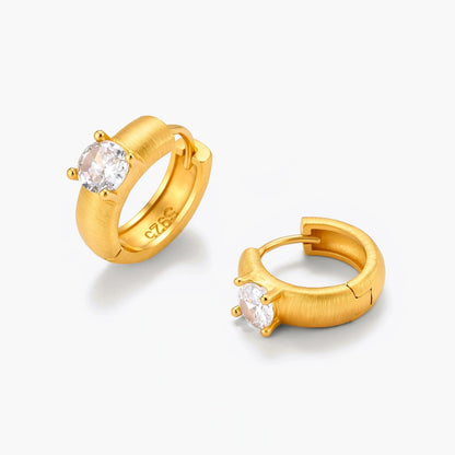 18K gold-plated 925 silver huggie hoops with brushed finish and prong-set round CZ solitaire, stamped S925 inside.
